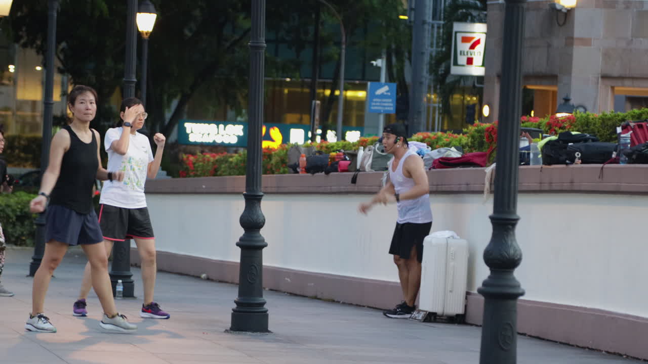 Group workout session outdoors in the city with people exercising together in Singapore