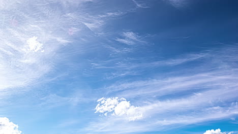 Beautiful-Cirrus-and-Cumulus-Clouds-Drift-High-Above-in-the-Blue-Sunlit-Skies-Forming-Shapes-and-Patterns-in-a-Motion-Timelapse