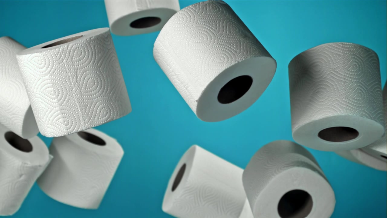 White Toilet Paper Rolls Floating on a Blue Background