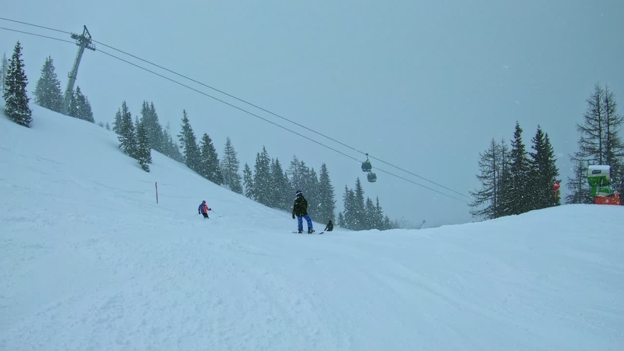 A teenager snowboarding downhill in snow storm