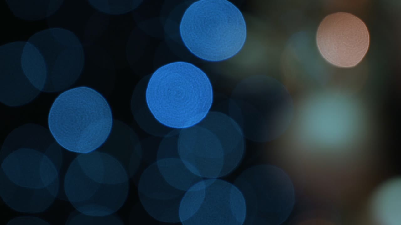 Blurred view of blue Christmas lights on a black background