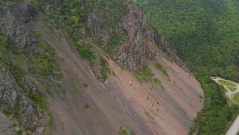 drone shot going backwards revealing the surrounding beautiful vistas of the cabot trail mountains located on cape breton island in nova scotia, canada shot in 4k during the summer