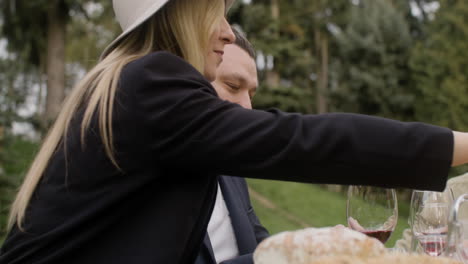 hombre de mediana edad comiendo y hablando con sus amigos sentados a la mesa durante una fiesta al aire libre en el parque 1