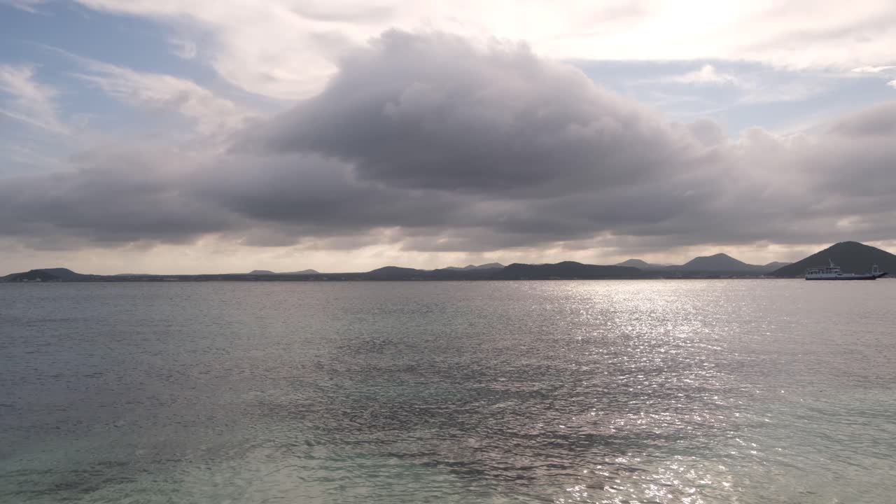 끝없는 바다 물과 수평선에 산의 광각 샷