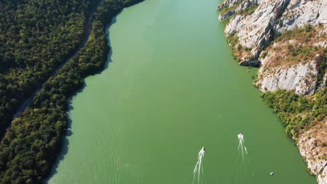 stunning aerial view of danube river canyon, surrounding mountains and boats