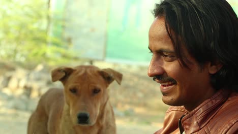 closeup-of-young-Man-talking-to-poor-street-dogs-with-one-dog-in-a-background