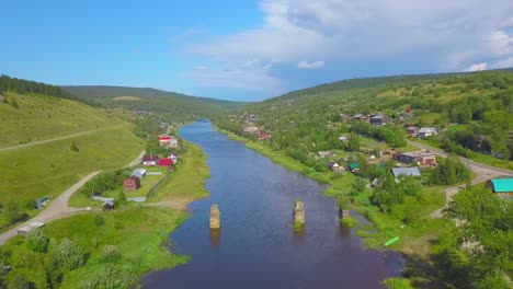 aerial view of a river flowing through a village in a valley