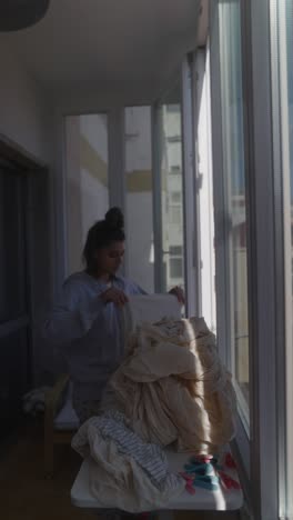woman drying clothes on a balcony