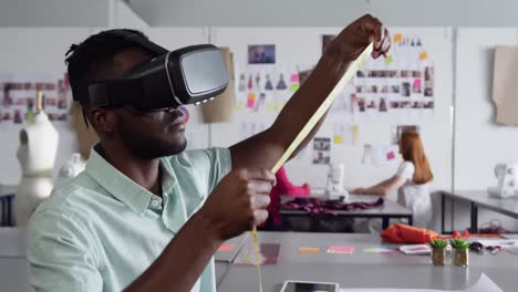 Mixed-race-man-wearing-VR-headset-in-fashion-office