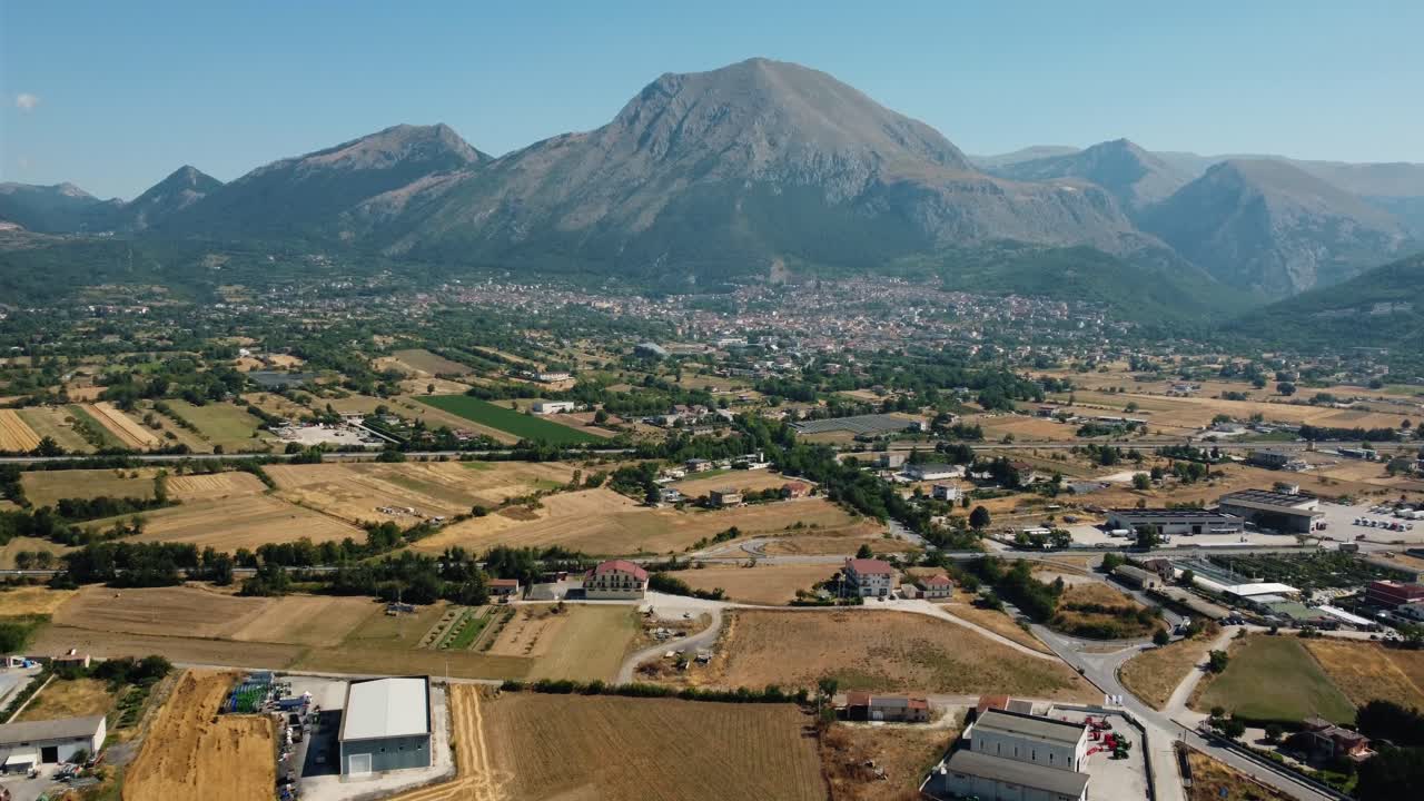 Aerial view of a town and surrounding countryside with a mountain in the background