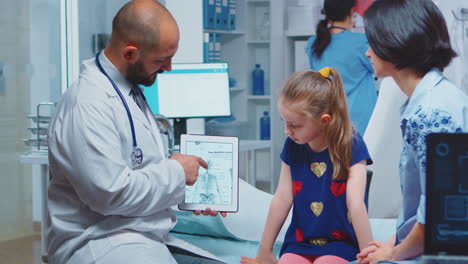 médico mostrando gráficos de esqueleto en la tableta