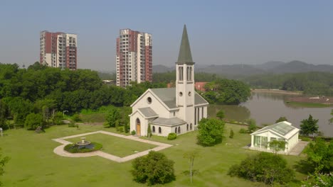 Edificio-De-Iglesia-De-Estilo-Católico-Sin-Cruz-Rodeado-De-Campos-De-Hierba-Verde-En-Un-Día-Claro-Y-Brillante