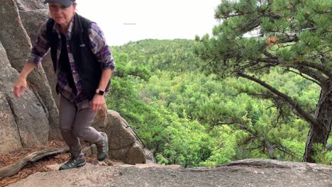 4K-Schussdame-Klettert-Im-Acadia-Nationalpark-Auf-Den-Bienenstockberg