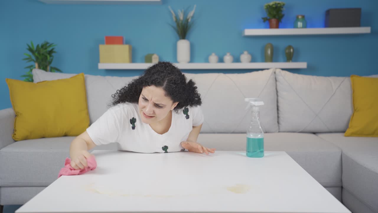 고집스러운 얼룩과 싸우는 젊은 여성.