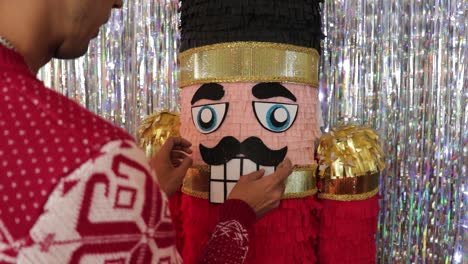 man in christmas jumper crafting large toy soldier nutcracker pinata