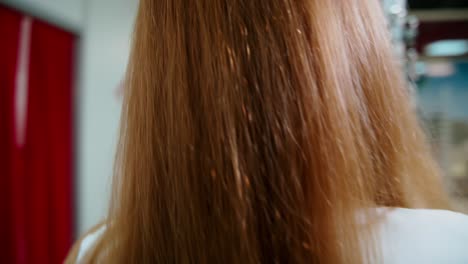 young blonde at optical store. attractive woman in elegant clothing twists the stand with eyeglasses. motion camera around.