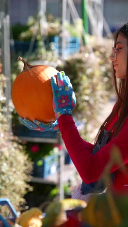 mujer sosteniendo una calabaza en un jardín