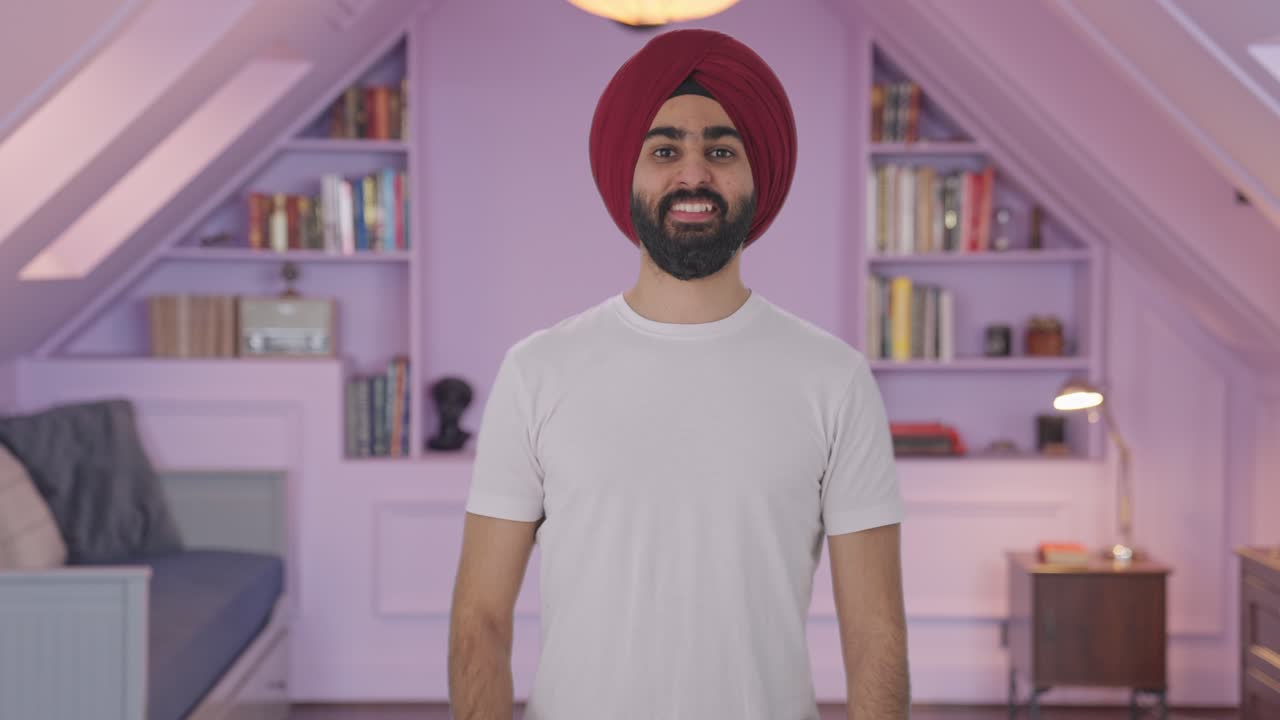 Uomo indiano Sikh felice che mostra il pollice in su