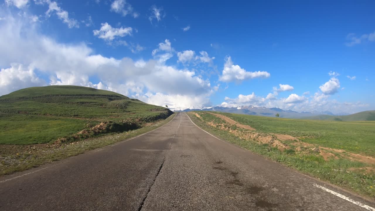 Guida di un'auto su strada (punto di vista). Il Monte Elbrus è visibile sullo sfondo.