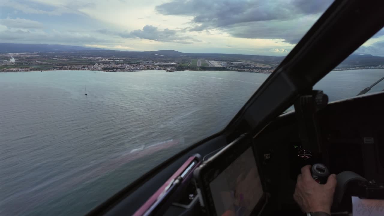 Un approccio immersivo in tempo reale visto dal pilota durante l'avvicinamento finale alla pista dell'aeroporto di Palma di Maiorca (PMI) (RWY 06L) durante l'ora blu con cielo nuvoloso. Vista della mano del pilota