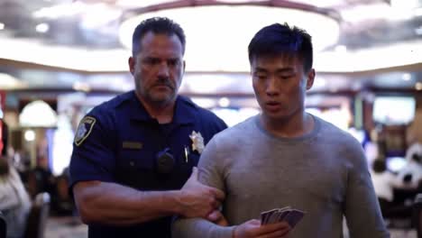 a law enforcement officer apprehends a suspected individual at a casino, capturing the tension of the moment in a bustling gaming environment