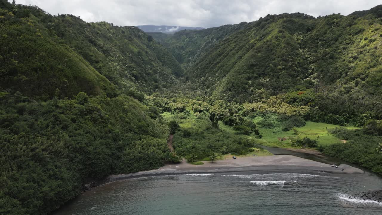 antena de playa rocosa en la costa de maui en hawaii con valle de montaña verde