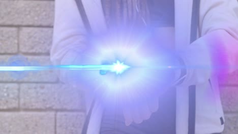 animation of light beam and lens flare over midsection of woman using smartwatch