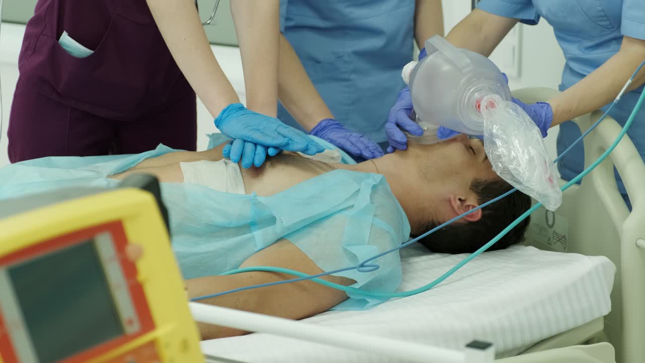 los médicos hacen reanimación a un paciente masculino en la sala de emergencias. masaje cardíaco. desfibrilación.