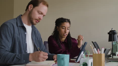 two colleagues collaborating and working together at an office desk