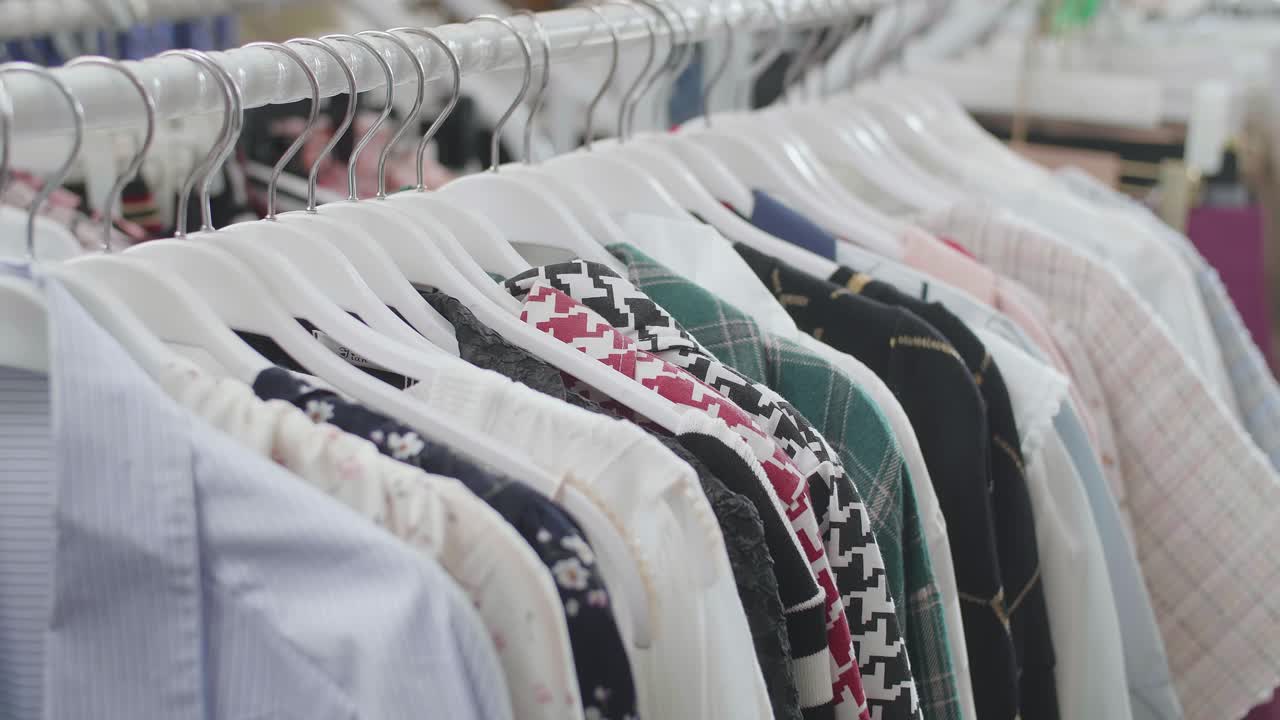 부티크의 선반에 있는 커에 있는 다양한 의류의 클로즈업