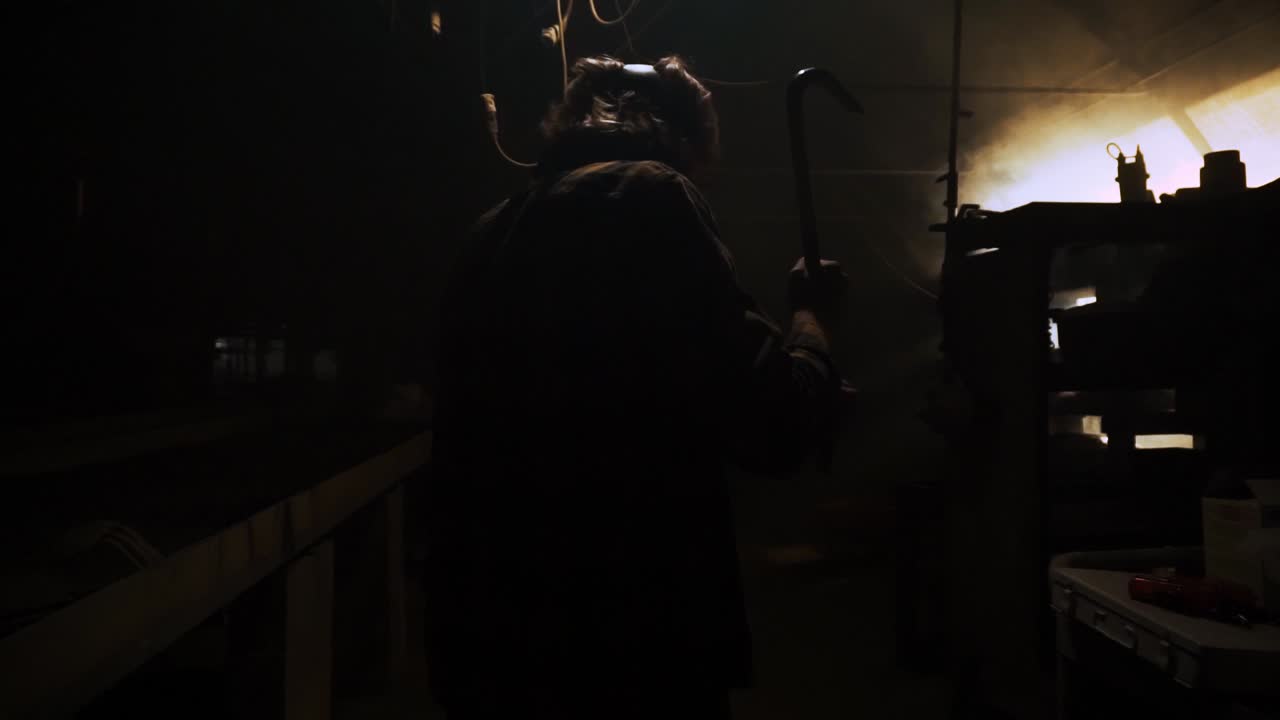 un tipo con una máscara de gas con una palanca caminando por una habitación espeluznante