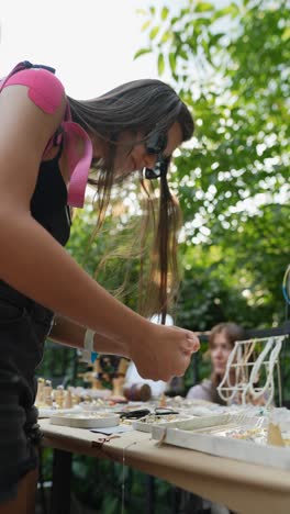 teenage girl browsing jewelry at an outdoor market