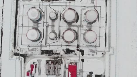 aerial view of oil storage tanks or reservoirs. oil refinery industry, petroleum and petrochemical plant, drone shot. oil tanks in winter. fuel crisis in winter.