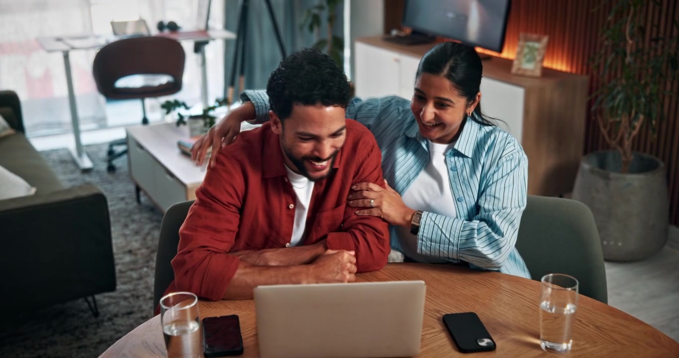 Happy Couple Celebrating Success While Using Laptop at Home