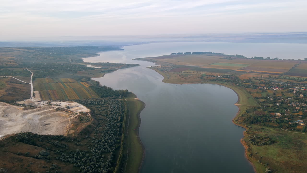 Aerial drone view of the Duruitoarea natural reservation in Moldova. River and fog in the air, hills and fields, village and quarry