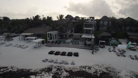 aerial reveal wide view of beautiful vacation home rental resort with pool and beach chairs