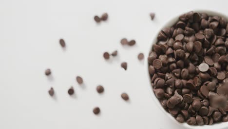 Video-of-overhead-view-of-bowl-of-chocolate-chip-over-white-background