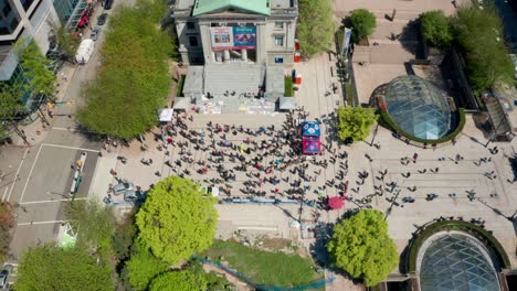 people gather to demonstrate in a public square, aerial drone view