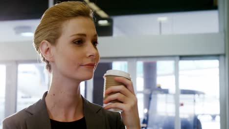 Businesswoman-having-coffee-from-disposable-cup