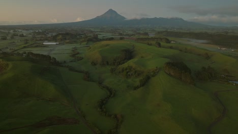 Reveal-shot-of-distant-Mount-Egmont-volcano-in-New-Zealand-during-sunrise