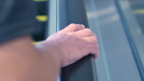 video de 4k en la mano mientras se agarra la computadora de mano en una escalera mecánica en una tienda por departamentos o en el aeropuerto