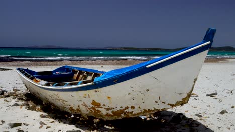 barco de pesca en una amplia playa mediterránea en la isla de cerdeña, italia