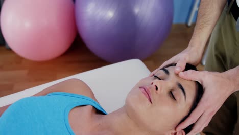 female patient receiving head massage from physiotherapist