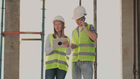 el controlador es un hombre de un edificio en construcción hablando por teléfono con la administración y ha discutido con el ingeniero y la arquitecta el progreso de la construcción.