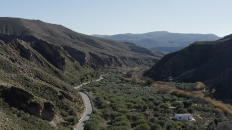 beautifully green mountainous valley a road running through and one white house