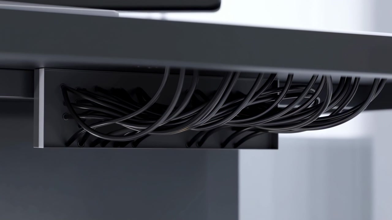 A close-up view of industrial fan blades rotating in a dark indoor environment, captured from a top-down perspective. The metallic construction and neutral lighting highlight the fan's use.