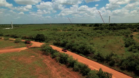 Work-Truck-on-dirt-road-with-wind-turbine-construction