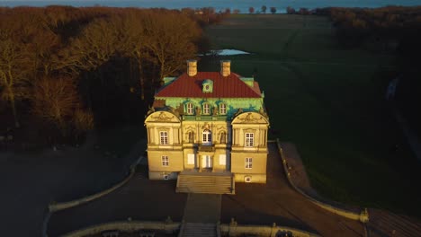 old luxury building lit by sunset sun, aerial fly over view