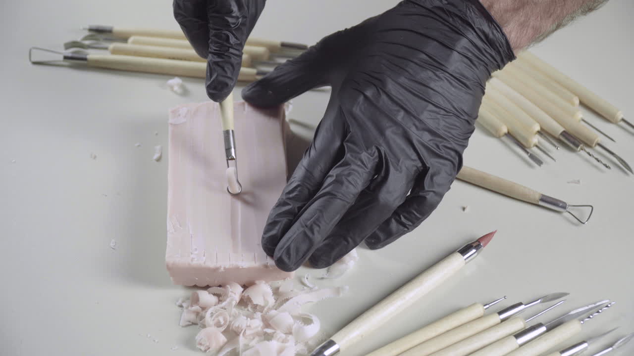 el artista usa una herramienta de cinta en un trozo de plastilina, cierra 4k