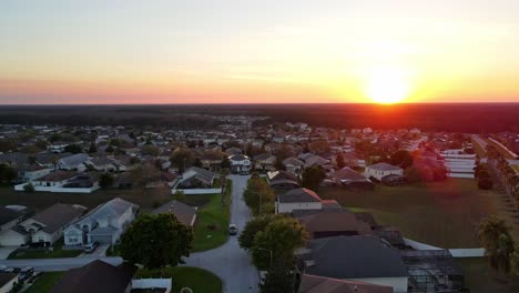 a drone 4k shot of the vacation homes in the southern warm climate with palm trees and a beautiful sunset